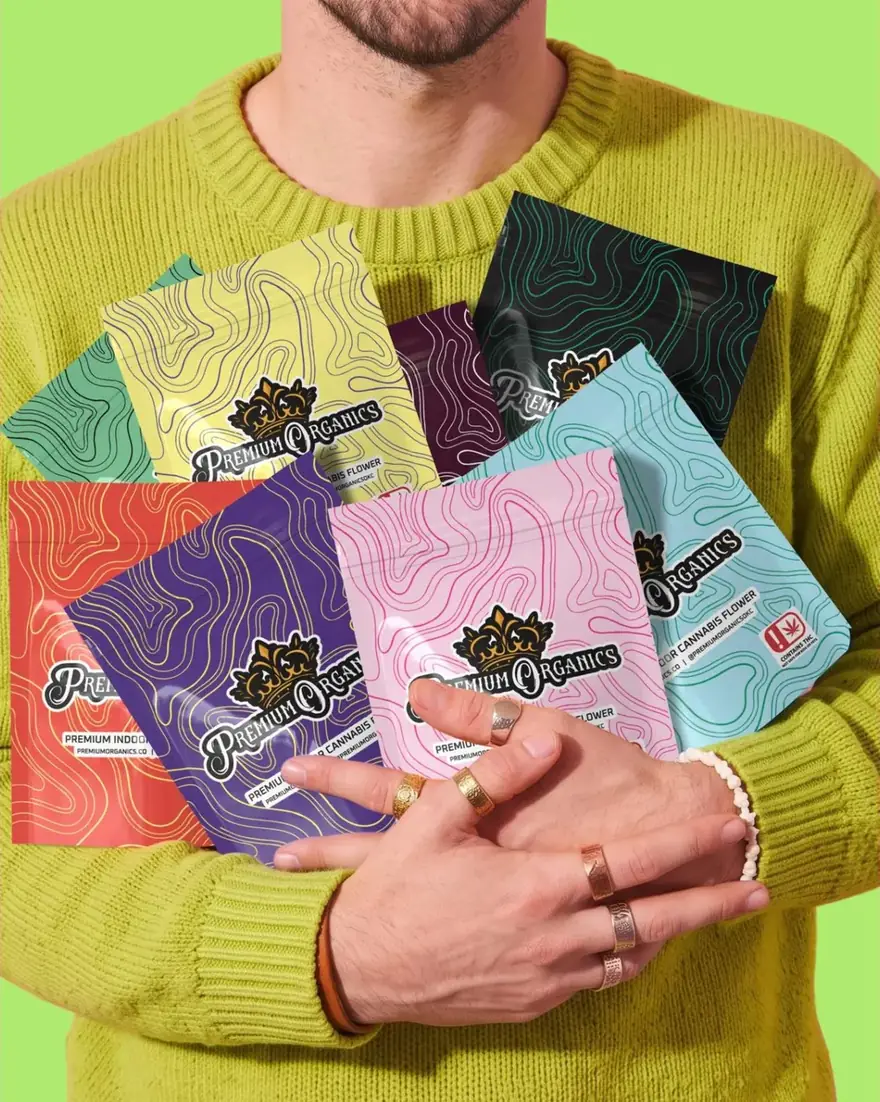 Person holding an armful of Premium Organics colorway bags